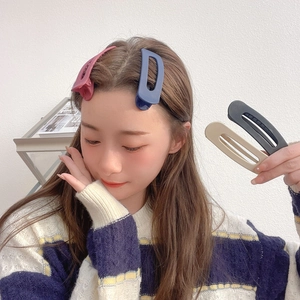 Detail view of large seamless hair clips in matte pink blue beige and black colors