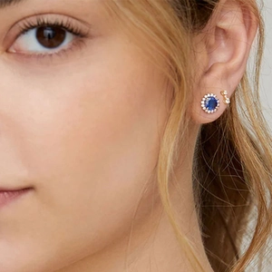 Close-up of S925 silver gold-plated studs with blue cat eye and smaller diamond earrings