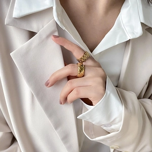 Goldene Gliederkette und gedrehte Ringe an Model für einen minimalistisch eleganten Look