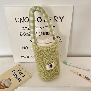 Detail of soft sage green fleece cup sleeve with checkered handle and cat patch