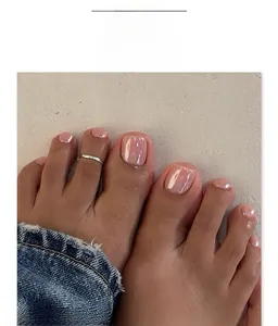 Close-up of pearl pink press-on toenails with a minimalist silver toe ring on skin