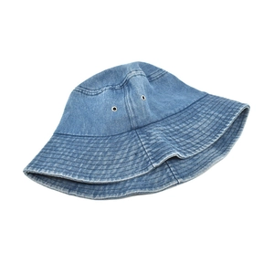 Detail view of washed blue denim bucket hat showing metal eyelets and stitched brim