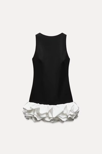 Detail view of the black sleeveless top and white ruffled hem on the bodycon dress