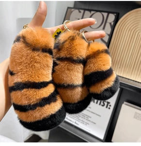 Detail of plush tiger tail keychains with striped faux fur and gold metal rings