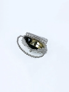 Close-up of a silver beaded handmade handbag with metallic spheres and gold compact