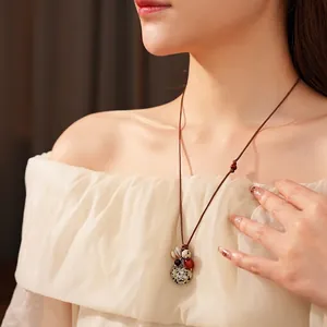 Bohemian wax rope heart necklace with wooden beads and textured pendant on model