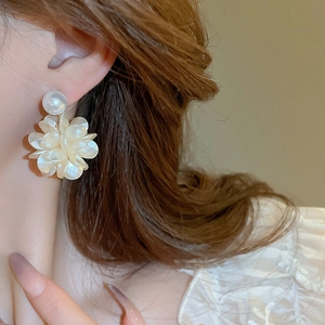 Details von Kamelienblüten-Ohrringen mit Perlensteckern für einen eleganten Look