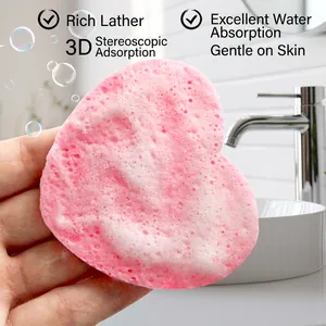 Pink heart-shaped facial cleansing sponge showing rich foam for skin washing