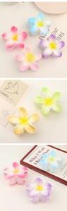 Detailed view of matte flower hair claws in colorful gradients and frosted textures