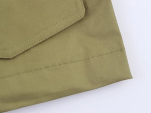 Détail de la parka vert armée montrant les coutures haute densité et le tissu sergé