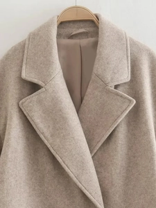 Detailed close-up of wool texture and wide lapels on an oatmeal casual winter coat