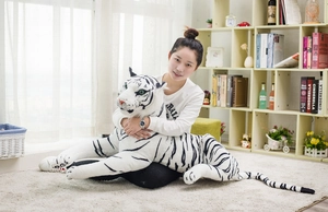 Detail of a large lifelike white tiger plush toy with realistic stripes and green glass eyes