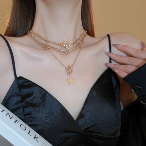 4-piece layered gold star necklace with Y2K chain and OT clasp on a model