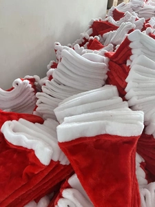 Massive pile of plush red and white Santa hats for festive holiday party decorations