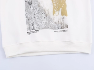 Detailed macro view of the ribbed hem and artistic abstract print on white cotton sweatshirt