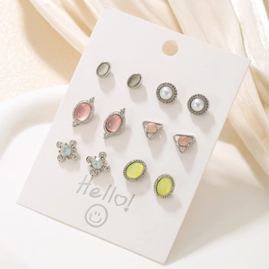 Detailed set of six pairs of mini animal-style colorful stud earrings on a white card display