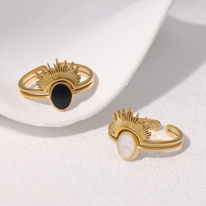 Detail of vintage 18k gold plated stainless steel sunburst rings with black and white enamel