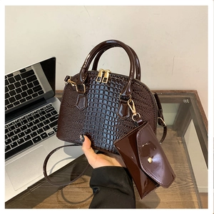 Detail of dark brown crocodile embossed tote bag set with matching small zipper pouch