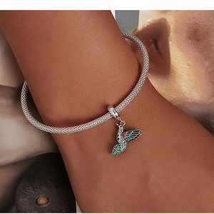 Gros plan sur le bracelet en maille argentée avec pendentif colibri coloré