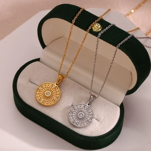 Detail of gold and silver compass pendants with sunburst texture on velvet