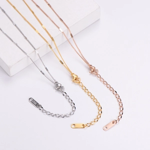Detail of lobster clasp and 18KGP tag on butterfly necklace in three metal finishes
