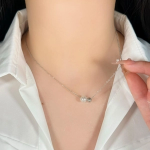 Minimalist titanium steel necklace with pearl and silver bead pendant on a model