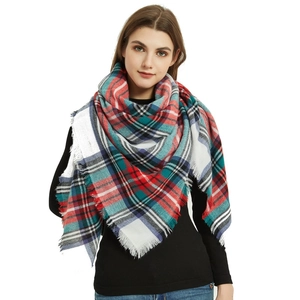 Detail of soft cashmere-like scarf showing large colorful checks and fringe edges