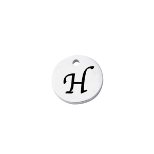 Close-up of a silver stainless steel round pendant with an engraved cursive letter H