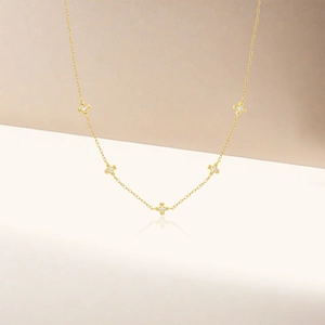 Detail of gold necklace with five cross pendants inlaid with white cubic zirconia