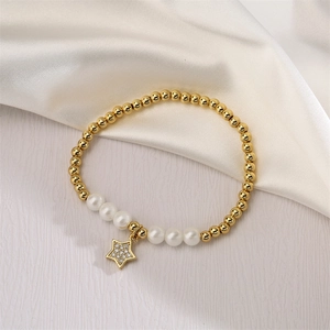 Detail of gold beaded bracelet featuring white pearls and a sparkling star charm on silk