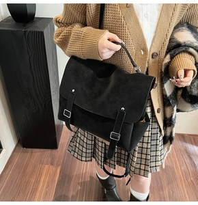 Primer plano de bolso tote negro mate con hebillas dobles y cierres de metal plateado