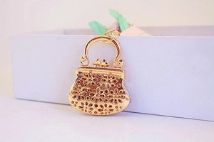 Detailed macro view of a gold hollow floral handbag pendant for keychains or bag charms