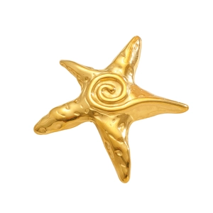 Macro detail of a polished golden starfish brooch featuring a spiral center and realistic texture