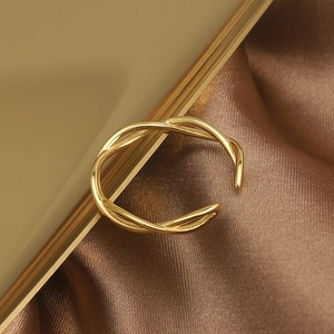 Detailed view of gold S925 silver interwoven twist ring on elegant silk background