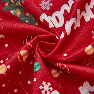 Close-up of red Christmas curtain fabric with mesh texture and festive holiday prints