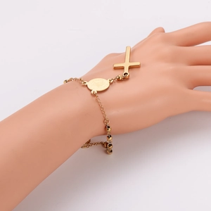 Gold stainless steel cross and religious medallion charm bracelet on a model hand