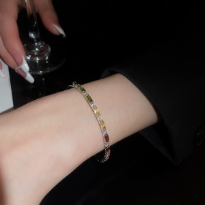 Macro detail of elegant silver bracelet with rectangular colored gemstones on a wrist