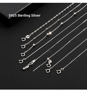 Macro detail of various S925 sterling silver chain styles including snake and bead chains