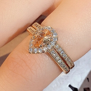 Macro-opname van champagne gouden druppelring met micro-pave zirkonia aan de hand