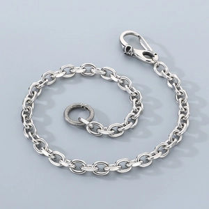 Close-up of silver punk trousers chain featuring a skull clasp and textured ring detail