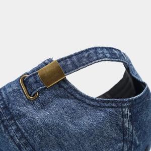 Detailed macro view of washed denim baseball cap with vintage brass adjustable buckle