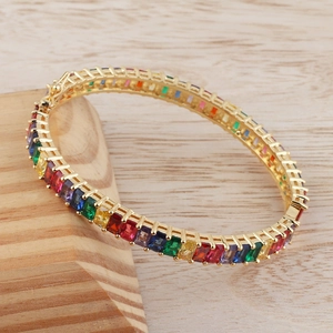 Detail of bohemian rainbow tennis bracelet with colorful gemstones and gold plated link