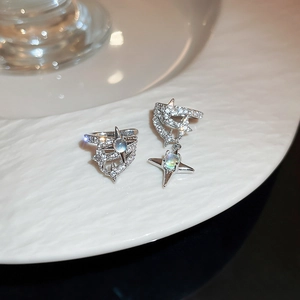 Close-up of star-shaped silver ear cuffs with pavé zircon and moonstone inlay details