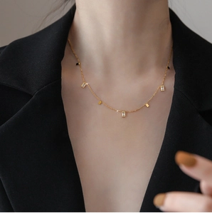 Close-up of gold tassel necklace with square crystal accents on a model's neck
