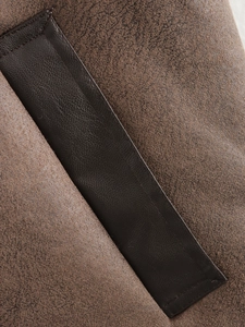Macro detail of brown waistcoat featuring premium faux leather and matte fabric patchwork