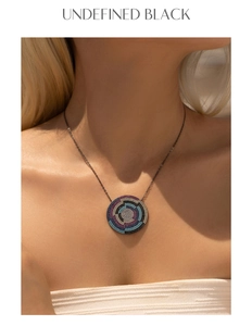 Detail of s925 silver necklace with turquoise swirl pendant on a black metal chain