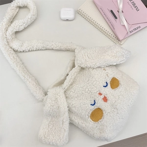 Dettaglio della borsa a tracolla in peluche bianca con ricamo e morbida ecopelliccia
