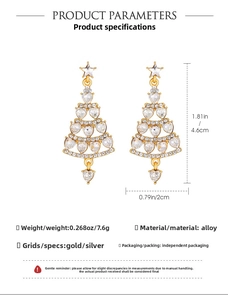 Detail of golden Christmas tree drop earrings with sparkling heart-shaped zircon stones