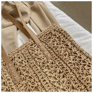 Detailed close-up of the woven texture and faux leather shoulder strap stitching on the tote