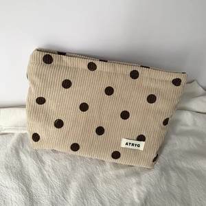 Close-up of beige corduroy polka dot bag with textured fabric and woven ATRYG label